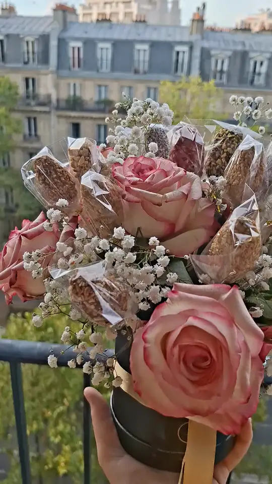 Bouquet de dattes fleuri, roses et gypsophile, tenu en main