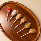 Six sucettes de dattes sur un plateau en bois